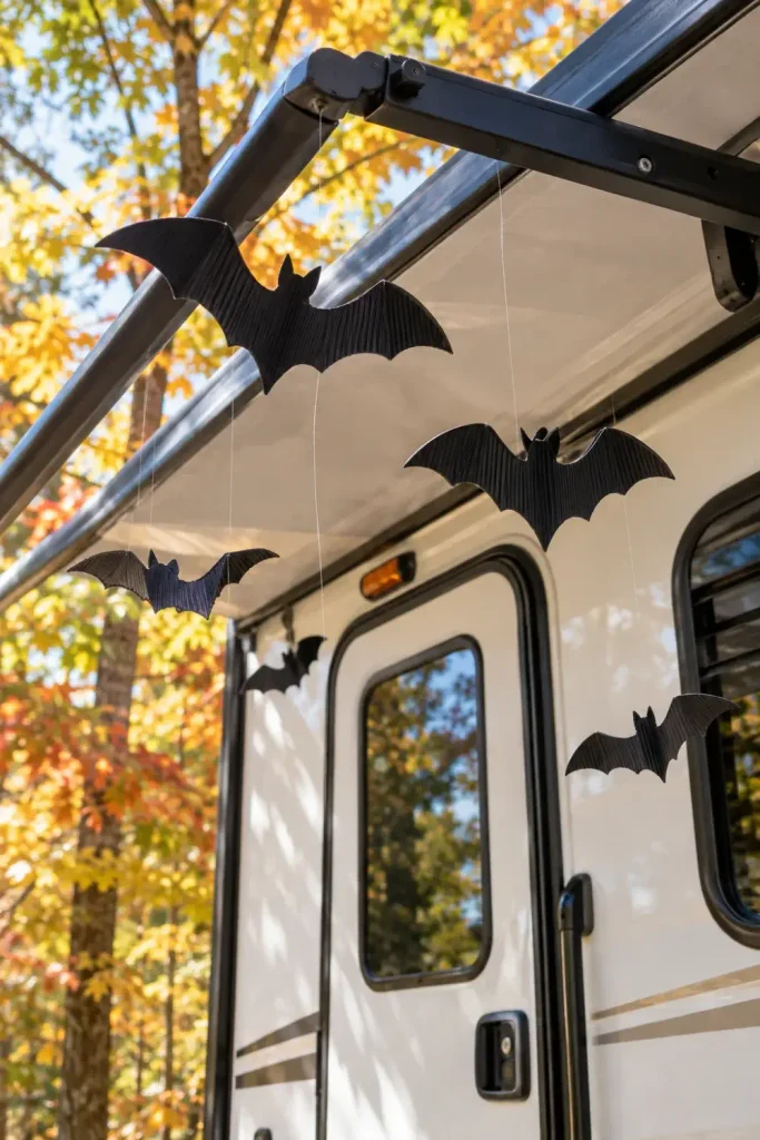Matte black plastic bats suspended with clear line from an extended RV awning arm above the doorway